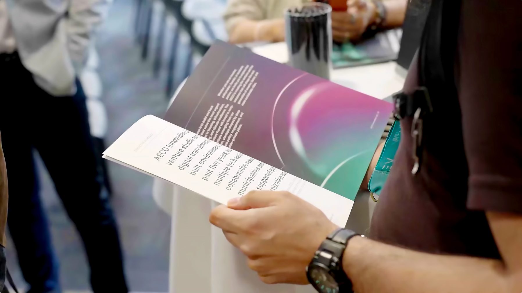 Attendee reading the AECO brochure at the event