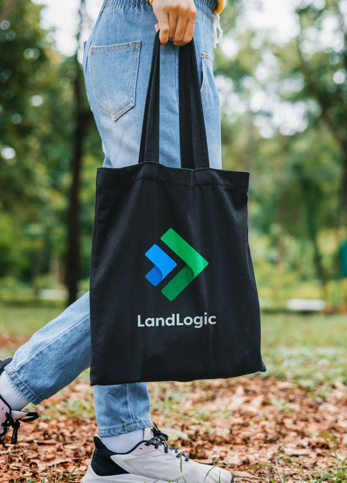 Person carrying a black LandLogic tote bag